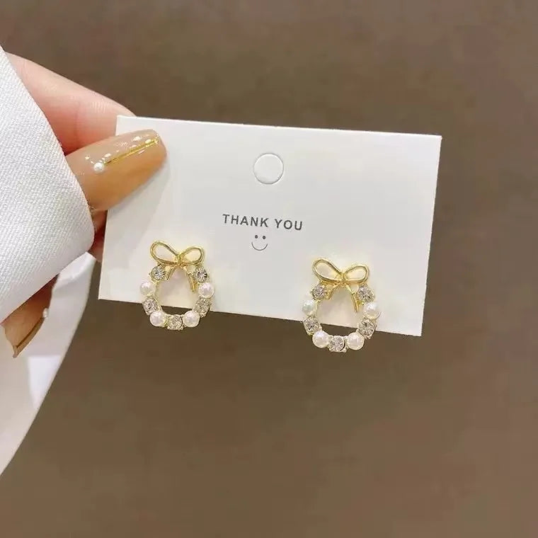 The 2025 high-quality retro and elegant earrings are diamond-encruffled bow pearl fashion earrings, suitable for the daily fresh