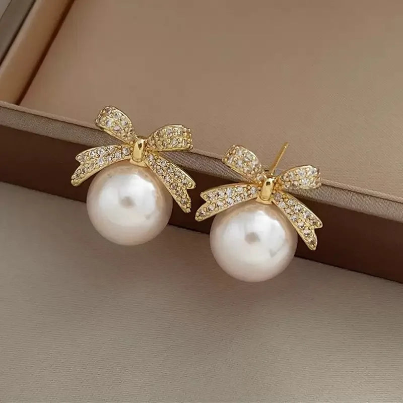 The 2025 high-quality retro and elegant earrings are diamond-encruffled bow pearl fashion earrings, suitable for the daily fresh