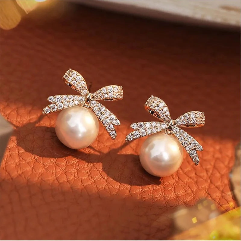 The 2025 high-quality retro and elegant earrings are diamond-encruffled bow pearl fashion earrings, suitable for the daily fresh